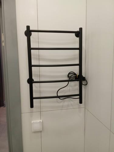 На стене закреплена металлическая конструкция с проводом, рядом выключатель. Установка завершена, все элементы надежно зафиксированы, обеспечивая функциональность и безопасность.