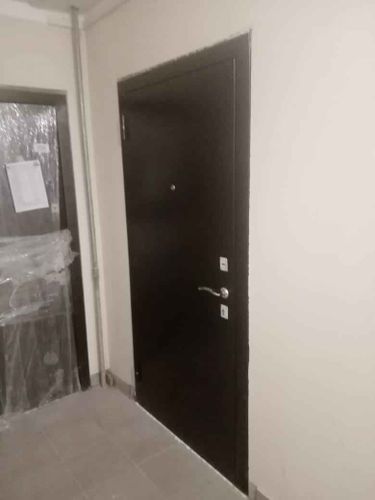 Металлическая дверь обшита панелями из МДФ, обновлена поверхность, улучшен внешний вид, добавлена звукоизоляция, установлены новые ручки и замки, завершена отделка.