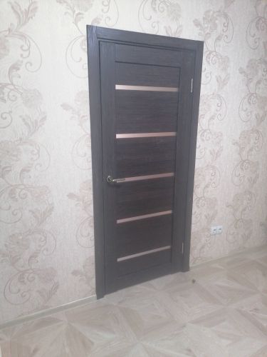 Изображена установленная дверь-гармошка: закреплены направляющие, створки соединены, ручка прикреплена, конструкция надежно зафиксирована в проеме. Завершенный монтаж в интерьере.