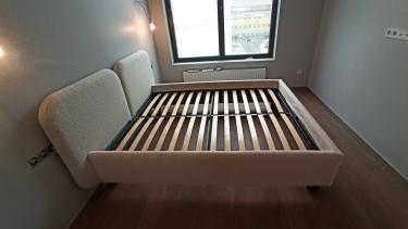 Собрана двуспальная кровать: установлены ножки, закреплено изголовье, уложены ламели, проверена устойчивость. Все элементы соединены, конструкция готова к эксплуатации.