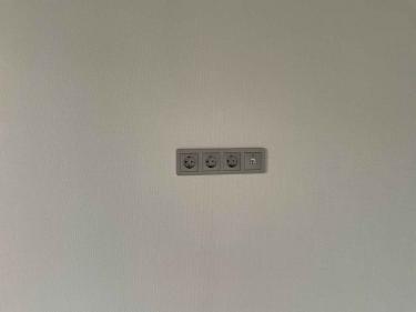 Установлены три электрические розетки и один сетевой разъем на стене. Все элементы аккуратно закреплены, обеспечивая безопасное подключение устройств.