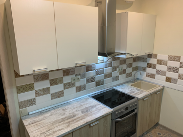 Установлены шкафы, смонтирована столешница, подключена плита, закреплена вытяжка, врезана мойка, уложен фартук из плитки, проведены коммуникации. Завершён монтаж кухонного гарнитура.