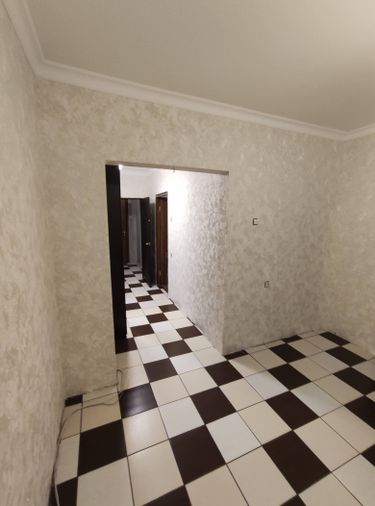 На стенах аккуратно наклеены фотообои с текстурой, создающей эффект объема. Поверхность ровная, без видимых швов и пузырей, что придаёт помещению стильный и современный вид.