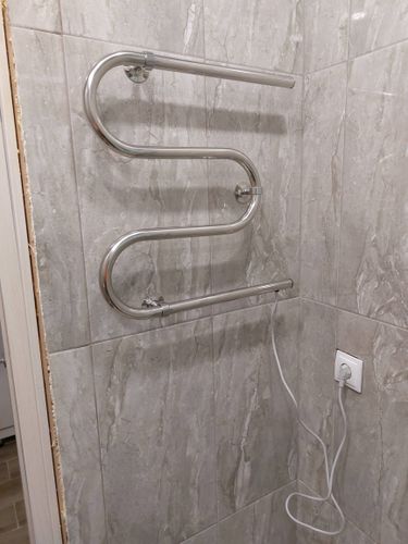 Установлено устройство для сушки полотенец на стену, подключено к электросети через розетку, закреплено крепежами, проверена работа, обеспечена безопасность использования.