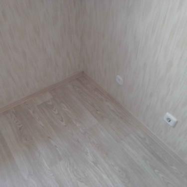 На ровное основание уложено покрытие, тщательно подогнаны стыки, установлены плинтусы, обеспечена плотная фиксация материала по периметру, поверхность выровнена, завершена отделка.