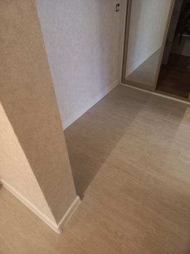 Покрытие уложено на подготовленное основание, стыки ровные, без зазоров. Установлены плинтусы, обеспечивая завершённый вид. Поверхность гладкая, без дефектов и неровностей.