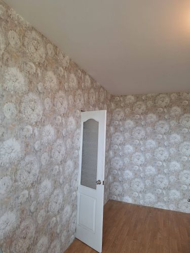 Стены покрыты стеклохолстом с узором, создающим текстурный эффект. Поверхность ровная и аккуратная, без видимых стыков. Работа завершена, интерьер выглядит обновленным и стильным.