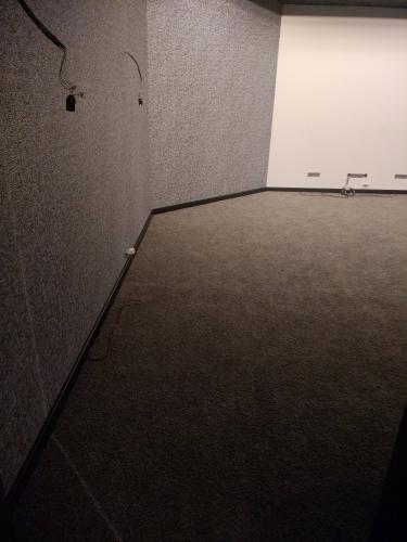 На полу уложены плитки ковролина, создающие ровное покрытие. Все элементы аккуратно подогнаны, швы незаметны. Завершена отделка, обеспечивающая комфорт и эстетичный вид помещения.