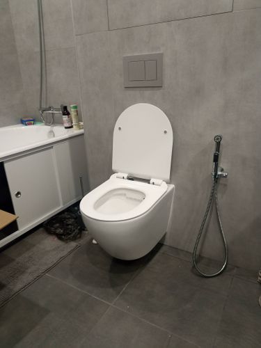 Установлен современный подвесной унитаз, подключены коммуникации, закреплена инсталляция, проверена герметичность, отрегулирована высота, смонтирована кнопка смыва, завершена облицовка стен.