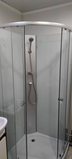 Установлена новая душевая кабина, заменены трубы, смонтированы стеклянные панели, подключены смеситель и лейка, герметизация швов, обновлена облицовка стен.