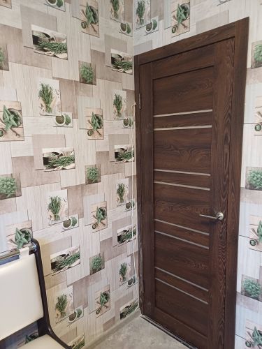 В деревянной двери аккуратно проделано отверстие, установлена фурнитура, закреплены ручки, механизм функционирует исправно, обеспечивая плавное закрывание и открывание.