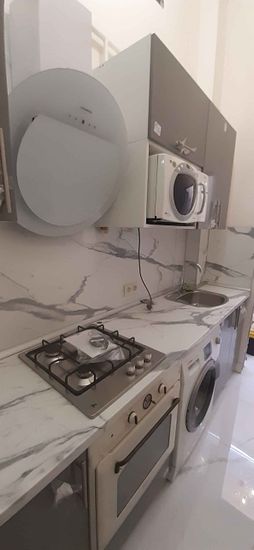 Установлены шкафы, закреплена столешница, подключены бытовые приборы, смонтирована мойка, размещена варочная панель, встроена вытяжка, подключена микроволновка, завершена отделка.