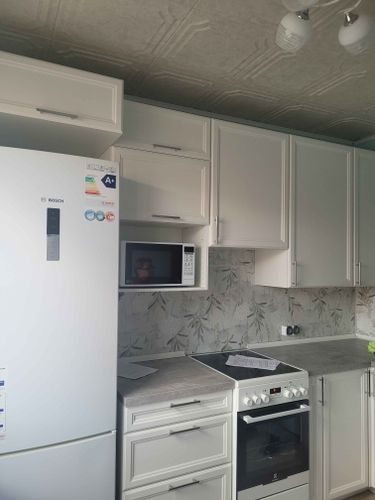 Установлены шкафы, закреплены фасады, смонтирована столешница, подключена техника, размещены ручки, выполнен монтаж фартука. Завершена сборка и установка кухонного гарнитура.