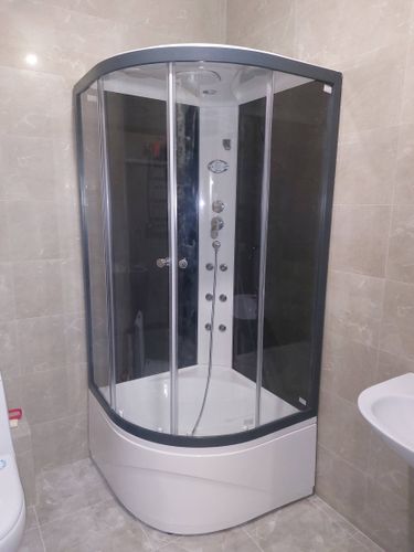 Установлена современная душевая конструкция с прозрачными дверцами, герметично закреплена, подключены водопроводные коммуникации, проверена функциональность всех элементов.