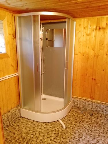 Установлена новая душевая кабина с полукруглыми дверцами, подключены водопроводные и сливные трубы, обновлено напольное покрытие, стены облицованы деревом.