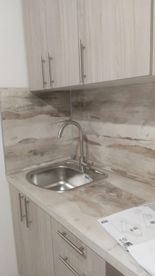 Установлены шкафы, закреплена столешница, встроена раковина, подключен смеситель, навешаны фасады, прикручены ручки, собраны ящики, установлены панели, завершена отделка.