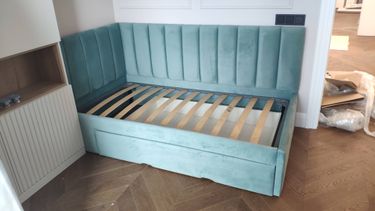 Изготовлен уютный диван с мягкой обивкой, установлен каркас, закреплены ламели, обеспечена надежная конструкция, подготовлено место для хранения, завершена сборка.