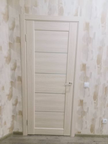 Установлена светлая дверь с одной створкой, закреплена в проеме, добавлены петли и ручка, отрегулирована для плавного открывания, обеспечена надежная фиксация в стене.