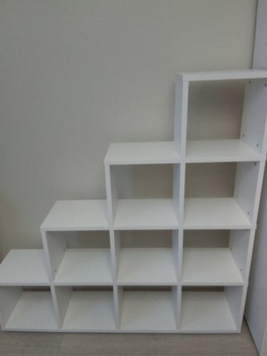 Собрана конструкция из белых полок, образующих ступенчатую форму. Установлены все детали, обеспечена устойчивость и функциональность. Работа завершена аккуратно и качественно.