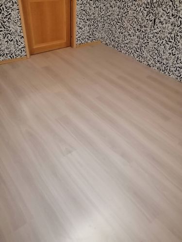 Панели аккуратно уложены на ровное основание, создавая гладкую поверхность. Завершено оформление стыков и установка плинтусов, обеспечивающих эстетичный вид и долговечность покрытия.