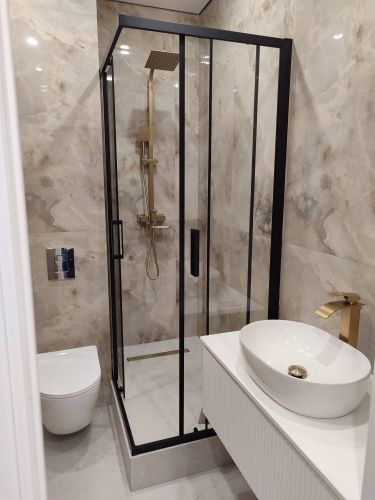 Установлена стеклянная конструкция с черной рамой, закреплены двери, подключен душевой комплект, герметизация швов, проверена функциональность. Завершено оформление современного санузла.