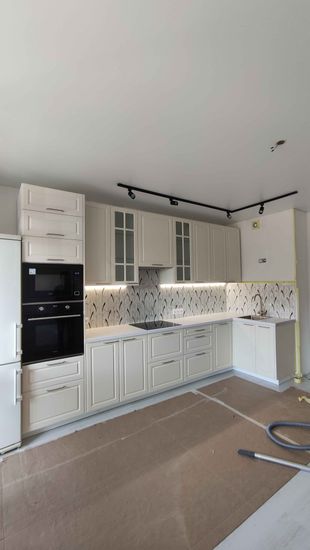 Установлены шкафы, смонтированы фасады, закреплены ручки. Подключена техника, установлена столешница. Смонтирована мойка, подключен кран. Установлено освещение под шкафами.