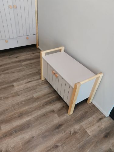 Собрано изделие с деревянными элементами и белыми панелями, установлено на ламинатное покрытие. Все детали соединены, конструкция устойчива и готова к использованию.