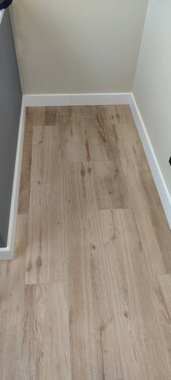 Установлен скрытый плинтус, аккуратно интегрированный в стену, создающий плавный переход между полом и стеновой поверхностью. Завершён монтаж, обеспечивающий эстетичный вид.