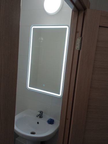 Установлен зеркальный шкаф с подсветкой над раковиной в ванной комнате. Закреплён на стене, подключено освещение, проверена устойчивость и функциональность.