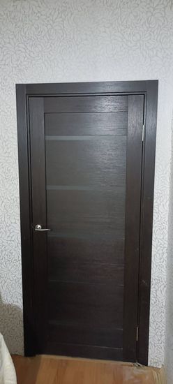 Выполнена установка запорного механизма в деревянное полотно. Проведены работы по вырезанию отверстия, закреплению ручки и проверке функционирования. Дверь закрывается плавно и надежно.