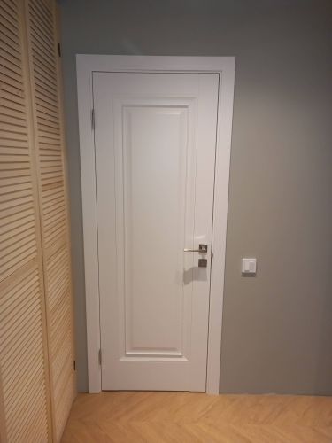 Установлена новая дверь с одной створкой, закреплены петли, врезан замок, отрегулирована фурнитура, выполнена отделка проема наличниками, проверена работа механизма.