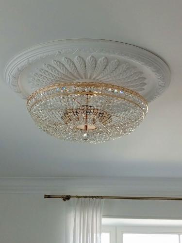 Установлена изящная люстра на потолке, закреплена надежно, подключена к электросети, обеспечивая освещение. Завершено оформление декоративного элемента, гармонирующего с интерьером.