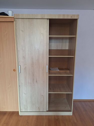 Собран корпус, установлены полки, закреплены направляющие, навешены двери, прикреплены ручки. Все элементы тщательно подогнаны, обеспечивая плавное скольжение и устойчивость конструкции.