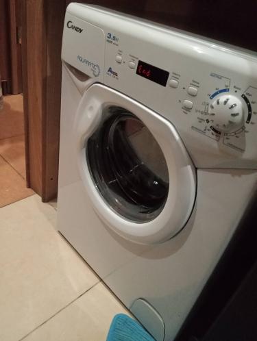 Изображена стиральная машина, установленная и подключенная к водопроводу и электросети. Проведены работы по обеспечению устойчивости, проверке герметичности шлангов и тестированию запуска.