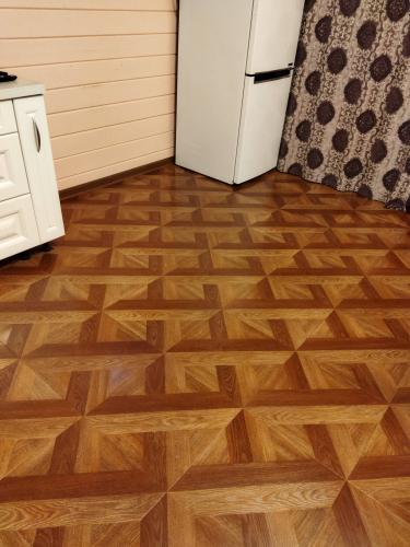 На полу уложено ламинированное покрытие с геометрическим узором, создающим эффект объема. Поверхность ровная, без зазоров, гармонично сочетается с интерьером помещения.