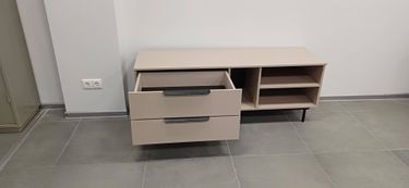 Собрана мебель с двумя выдвижными секциями и открытыми полками. Установлены ручки, закреплены направляющие, проверена плавность движения ящиков. Готовый предмет установлен на место.