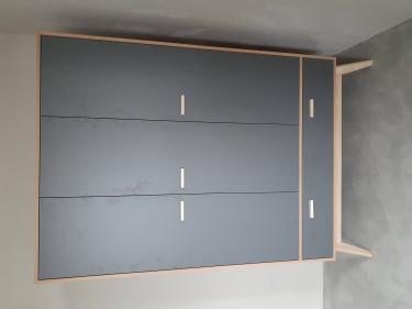 Собран шкаф с тремя дверцами и двумя выдвижными ящиками, установлен на ножки. Цвет фасадов серый, корпус светлый. Работа завершена, конструкция устойчива, функциональна.