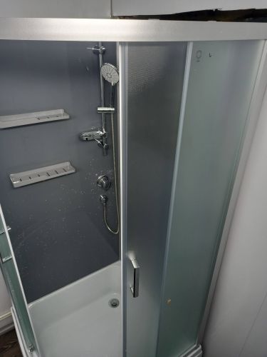 Установлены стеклянные панели, закреплены направляющие, подключен смеситель, смонтирован поддон, герметизация швов, проверена герметичность, установлены полки и дверцы.