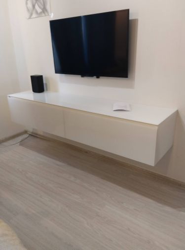 Собрана белая подвесная тумба с ящиками. Установлены направляющие, закреплены фасады, проверена плавность выдвижения. Готовая конструкция надежно закреплена на стене.