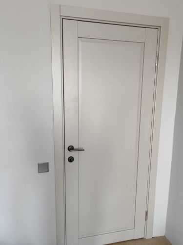 Установлена светлая межкомнатная дверь с ручкой и замком, закреплена в проеме, ровно навешана, плотно прилегает к коробке, обеспечивая плавное открывание и закрывание.
