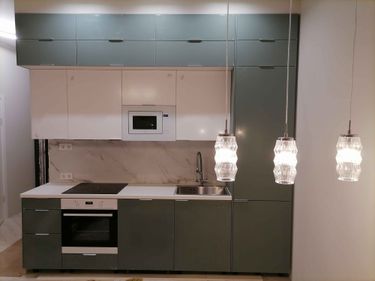 Установлены шкафы, закреплены фасады, вмонтирована техника, подключены коммуникации, установлена столешница, смонтированы осветительные приборы. Завершена отделка стен.