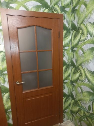 Установлена деревянная дверь с матовым стеклом, закреплена ручка, петли, отрегулировано полотно, проверена плавность закрытия, обеспечена герметичность, завершена отделка откосов.