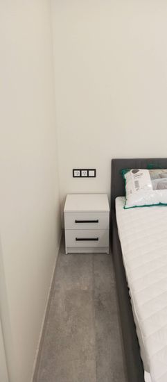 Собрана компактная тумба с двумя выдвижными секциями. Установлены ручки, ящики плавно открываются. Конструкция устойчива, размещена рядом с кроватью, гармонично вписывается в интерьер.