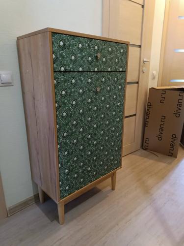 Собран шкаф с узорчатыми дверцами, установлен на ровную поверхность. Все детали аккуратно соединены, обеспечивая устойчивость и функциональность. Работа завершена качественно и профессионально.