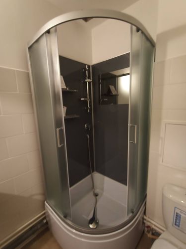 Установлена современная душевая конструкция с полукруглыми стеклянными дверцами, заменены трубы, проведены отделочные работы, смонтированы полки и душевой гарнитур.