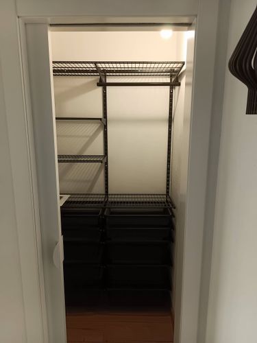 Установлена металлическая конструкция с полками в шкафу. Закреплены элементы, обеспечивающие устойчивость и функциональность. Завершено оформление пространства для хранения вещей.