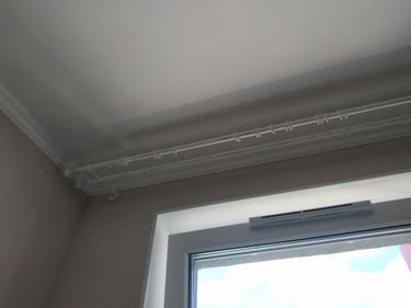Закреплены направляющие для штор на поверхности потолка. Установлены крепления, обеспечивающие надежную фиксацию. Завершено оформление оконного проема для подвешивания занавесей.
