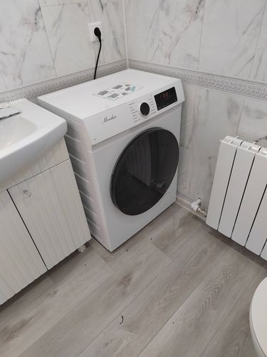 Изображение демонстрирует завершённый монтаж сантехнического оборудования в ванной комнате. Установлены коммуникации, закреплён подвесной унитаз, подключены все необходимые инженерные системы.