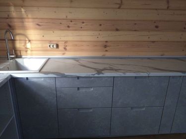 Установлены шкафы, закреплена столешница из искусственного камня, вмонтирована раковина и подключен смеситель. Все элементы выровнены и надежно зафиксированы.