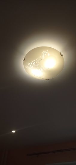 Закрепление светильника на натяжном потолке выполнено. Установлены крепежи, подключены провода, обеспечена надежная фиксация. Светильник функционирует, освещение равномерное.